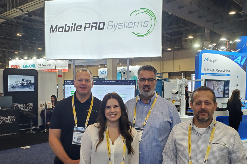 Mobile Pro Systems team members pose for a photo in front of a booth display at ISC West 2025.